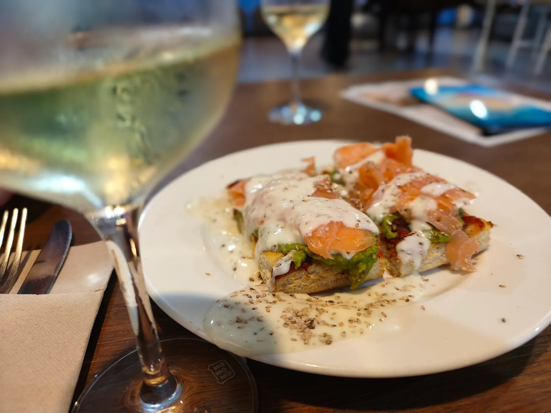 Tosta de salmón y aguacate con una copa de vino blanco